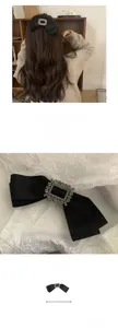Détail d'un nœud à cheveux en satin noir avec une boucle carrée en strass brillants