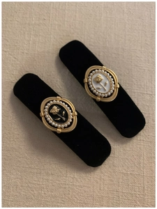 Detail of vintage velvet hair clips with golden camellia flower and pearl inlay