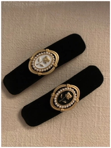 Detail of vintage black velvet hair clips with embossed rose and pearl border