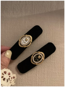 Close-up of velvet hair clips with pearl borders and floral embossed center details