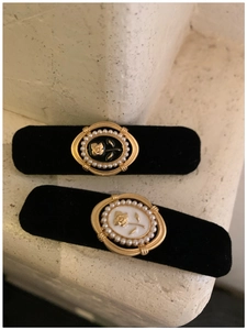 Detail view of retro velvet hair clips featuring rose patterns and pearl embellishments