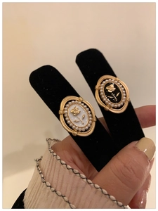 Close-up of vintage french style rose earrings with black and white enamel and pearls
