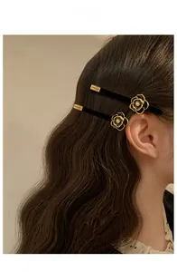 Fermaglio vintage camelia nera con perla indossato lateralmente su capelli di una modella
