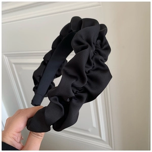 Elegant black pleated headband with elastic shimmer fabric for a high crown voluminous look
