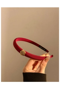Gros plan détaillé du serre-tête en satin rouge fait main avec une rose dorée élégante