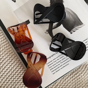 Detail view of four infinity hair claws in matte black, amber, and tortoiseshell finishes