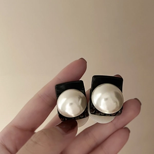 Detail shot of small pearl hair claws with black square base and white pearls