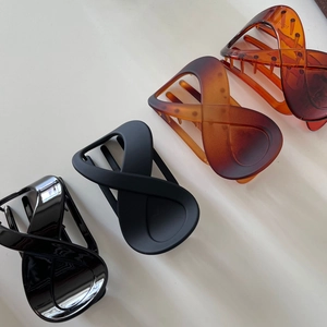 Set of four infinity-shaped hair claw clips in matte black, glossy brown and amber resin