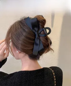 Nahaufnahme einer großen schwarzen Satin-Schleifen-Haarklammer für elegante Hochsteckfrisuren