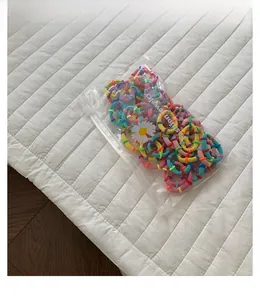 Detail of colorful elastic hair bands set in a matte zipper bag with daisy pattern