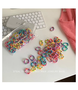 Close-up of vibrant elastic hair ties in a daisy-patterned bag on a stylish desk