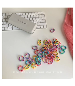 Close-up of colorful high-elasticity braided hair ties scattered on a white desk