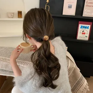 Elastisches Haargummi mit runder Bernstein-Perle für Pferdeschwänze bei braunem Haar