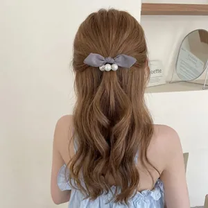 Elegant French vintage grey satin bow hair tie with pearls on brown curly hair