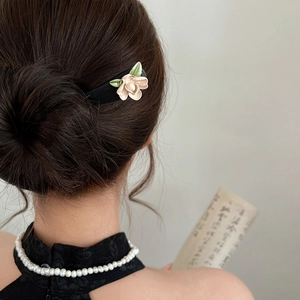 Close-up of elegant wooden hair stick with pink flowers for traditional hair buns