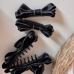 Detail of black satin bow hair clip with sparkling rhinestones and non-slip grip