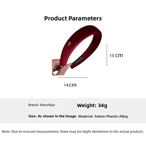 Detail view of burgundy velvet padded headband showing handmade label and golden metal ornament