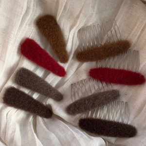 Detailed view of plush oval hair combs and clips in four warm autumn colors