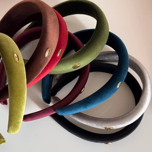 Retro padded velvet headbands in assorted colors with elegant gold metal logo detail