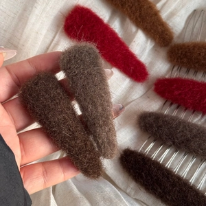 Close-up of plush oval hair comb set in dark coffee, red, and brown warm tones