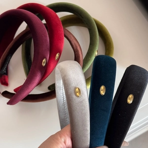 Detailed close-up of velvet sponge headbands with handmade label and gold buckle