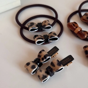 Close-up of leopard print bow hair clips and hair ties with France Handmade engraving