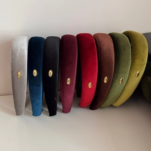 Detailed close-up of handmade velvet headbands in various colors with gold metal accent
