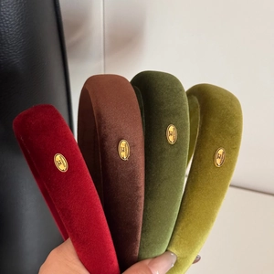Detail of velvet padded headbands in four colors with gold handmade metal tags