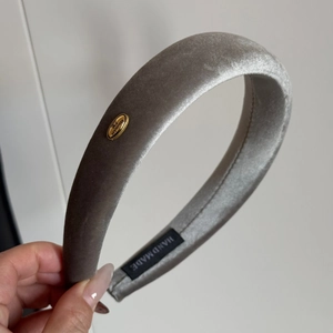 Detail of silver gray velvet padded headband with handmade metal tag and soft texture
