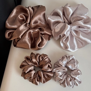 Detail of satin scrunchies set in brown and champagne gold with rhinestone accents