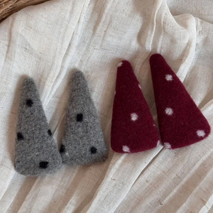 Détail de quatre barrettes en feutre de laine avec des motifs à pois élégants et chics