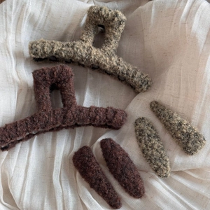 Detail shot of plush autumn hair clips set in brown and camel faux lamb wool texture
