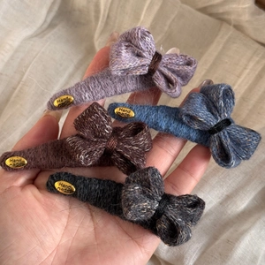 Détail de quatre barrettes à cheveux avec nœuds en tricot faits main en violet et bleu