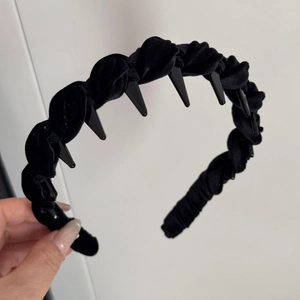 Detail of black velvet padded headband featuring non-slip plastic inner teeth for grip