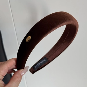 Detail of coffee brown velvet padded headband with gold logo and handmade label