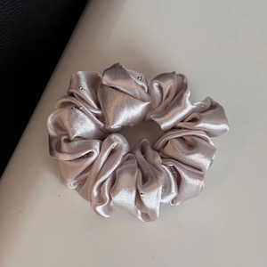Detailed shot of champagne satin scrunchie with sparkling silver rhinestones