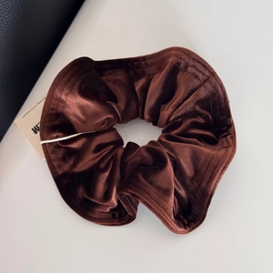 Detailed view of dark brown velvet scrunchie showing thick texture and soft sheen