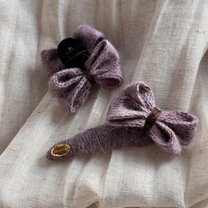 Détail macro d'un ensemble de barrettes noeuds tricotés violets avec étiquette dorée