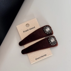 Detail of dark brown velvet hair clips featuring octagonal crystal and black rhinestones