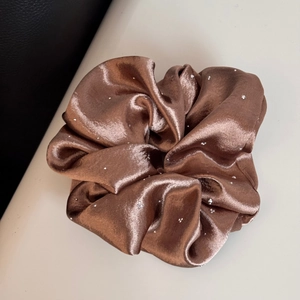 Macro shot of coffee brown satin scrunchie featuring sparkling silver rhinestones