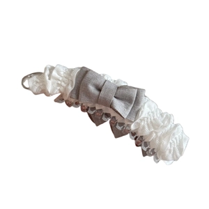 Elegante haarclip met witte geplooide kant, grijze strik en transparante basis