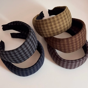 Detailed stack of five plaid headbands in various colors with thick fabric texture