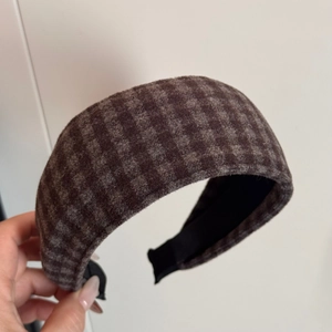 Detail of brown plaid flannel wide headband with thick texture and black fabric lining