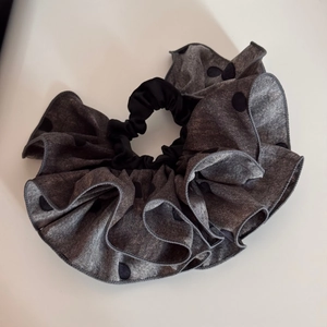 Vue détaillée du chouchou gris surdimensionné à volants avec tissu à pois noirs chic