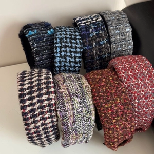 Close-up of assorted tweed headbands showing thick knit texture and varied color patterns