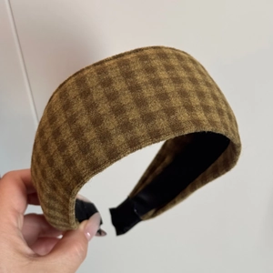 Close-up of retro brown plaid flannel headband showing soft wool texture and wide padded design