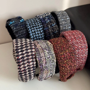Close-up of assorted tweed wide headbands in various colors with thick knit texture