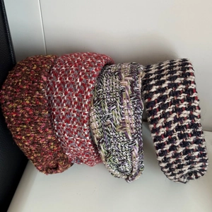 Detail view of four tweed knit headbands in various colors with sponge padding