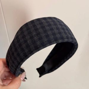 Macro detail of British plaid wide headband with grey check flannel texture and soft inner lining