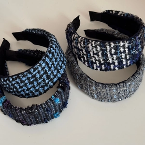 Detailed close-up of textured tweed headbands in houndstooth and sequin knit patterns